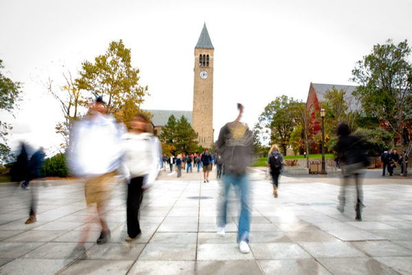 Blurred students walking in front of Cornell's Clocktower
