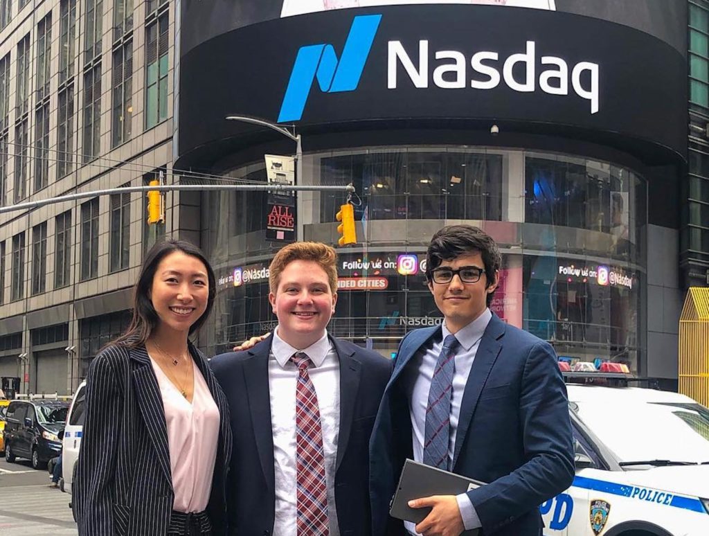 Three Hotelies stand in front of the Nasdaq building