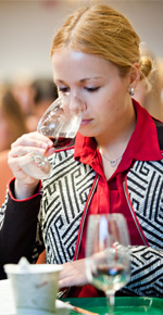 a student breathes in the aroma of a wine during a tasting in 2015